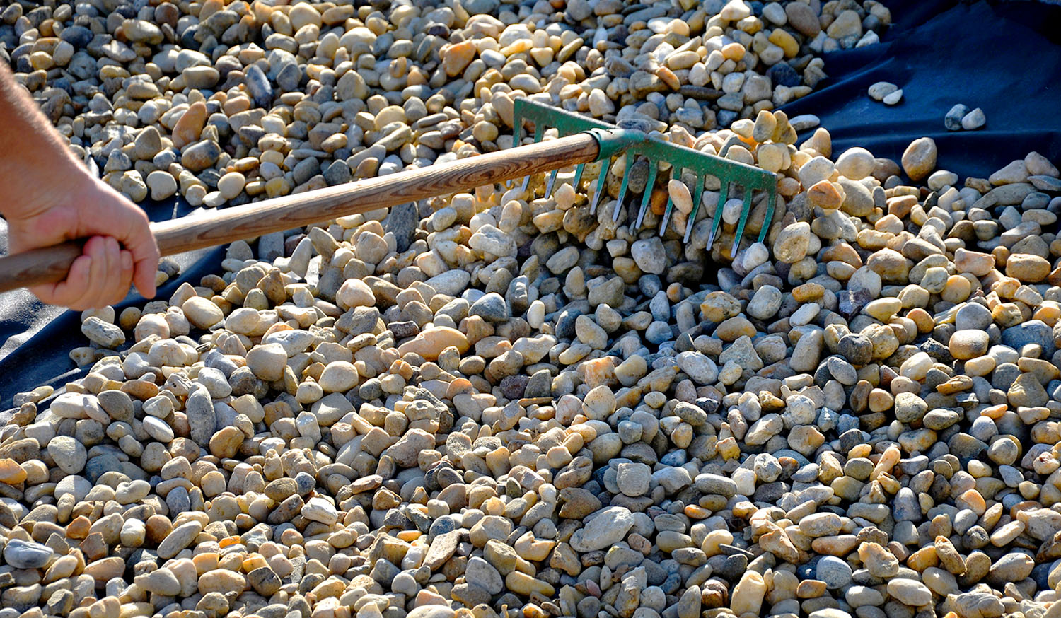 Landscaper spreading out gravel evenly